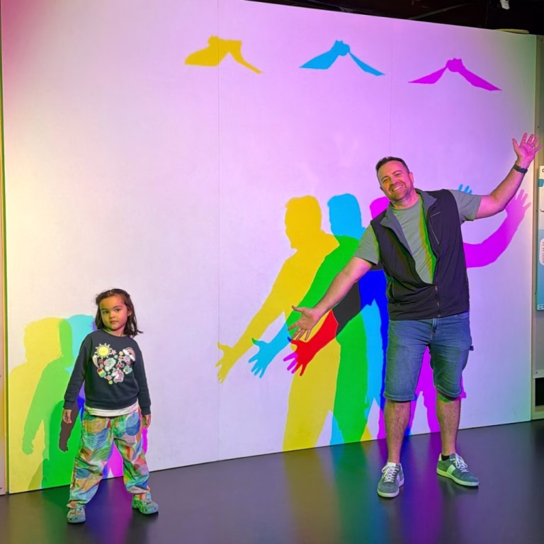 Murray and his daughter casting a rainbow silhouette on the Coloured Shadows wall at SparkLab
