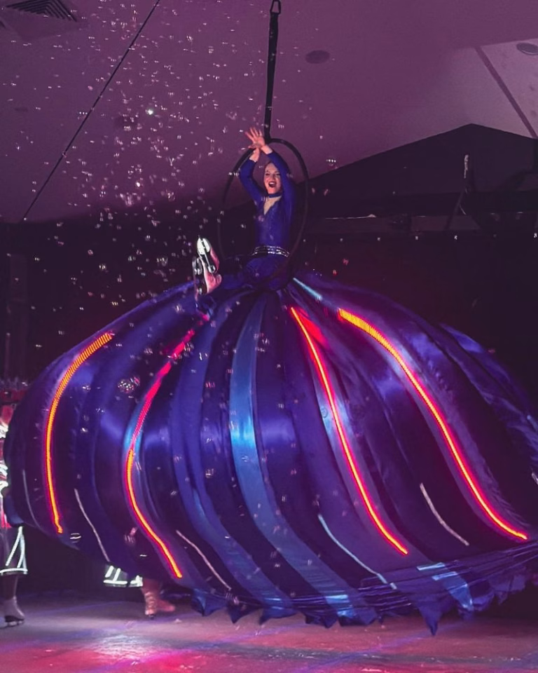 A performer's light-up costume trails through the air during an acrobatic sequence at Rock on Ice, Planet Chill ice skating rink, Paradise Resort Gold Coast
