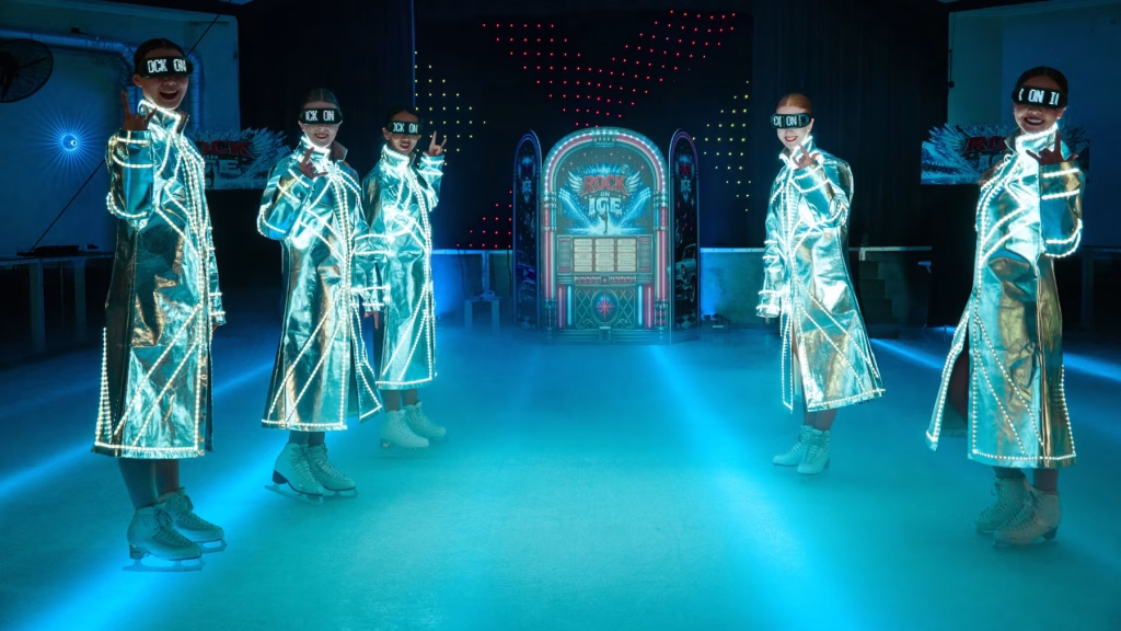 Performers in light-up costumes ice skating under coloured lights at the Rock on Ice premiere, Planet Chill ice skating rink, Paradise Resort Gold Coast