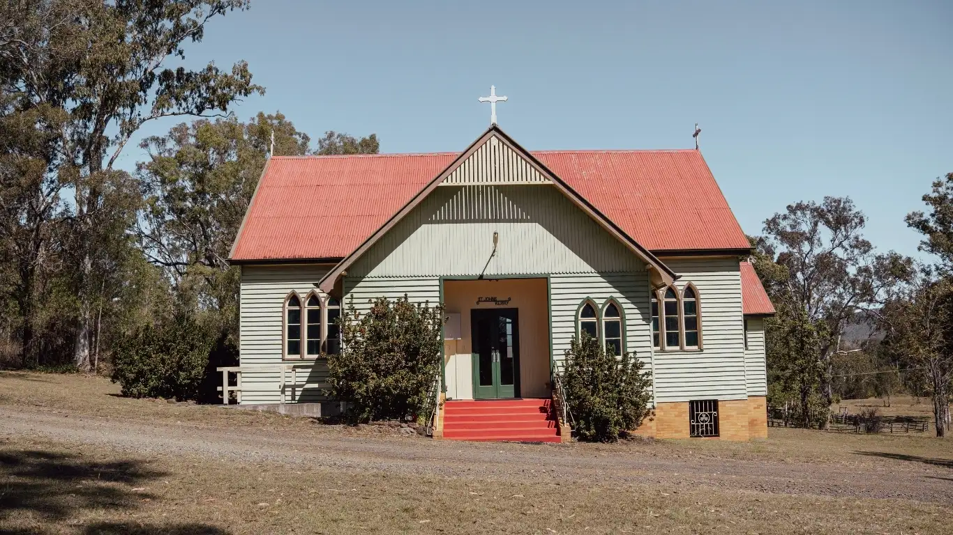St John's Catholic Church in Kerry, a small timber church on a hill with its cemetery behind it, in the Scenic Rim