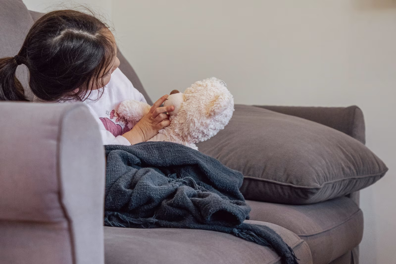 Young girl playing with her teddy bear inside Widgee Cottage at Worendo Cottages, a family farm stay near Brisbane