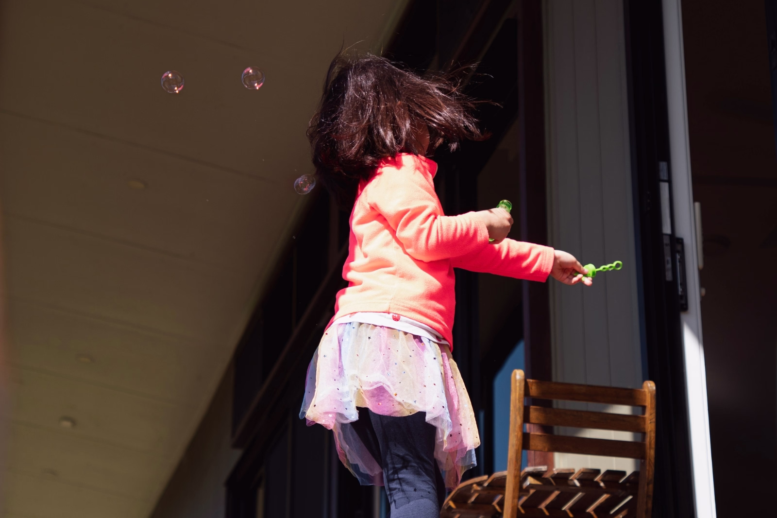 Young girl chasing bubbles on the Widgee Cottage verandah at Worendo Cottages, a Scenic Rim farm stay with kids